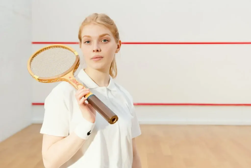 Classic White Polo Shirt Trend for Sports Clubs - T-Shirt Printing KL | Custom Shirt Printing Malaysia Female tennis player holding a racket wearing a classic white custom polo shirt, illustrating minimalist sportswear trends in malaysia.