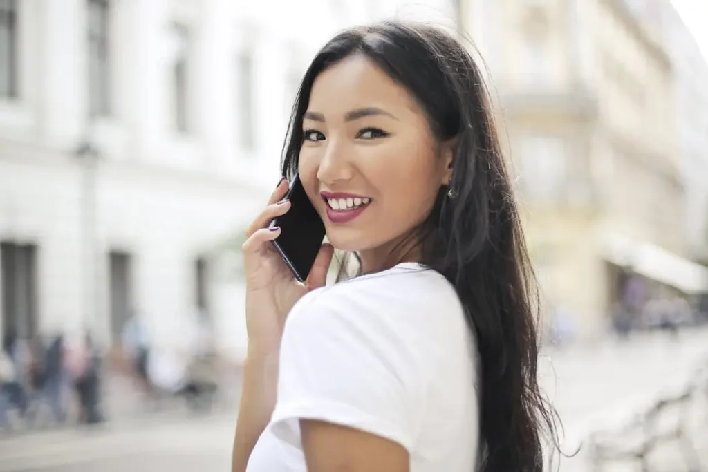 Smiling woman talking on a mobile phone looking back over her shoulder, representing expert customer support for printing advice.