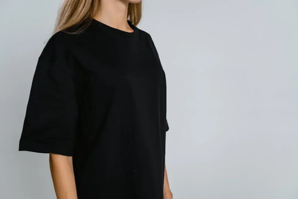 Woman wearing a plain black oversized t-shirt, illustrating the canvas for testing print opacity and vibrancy on dark garments.