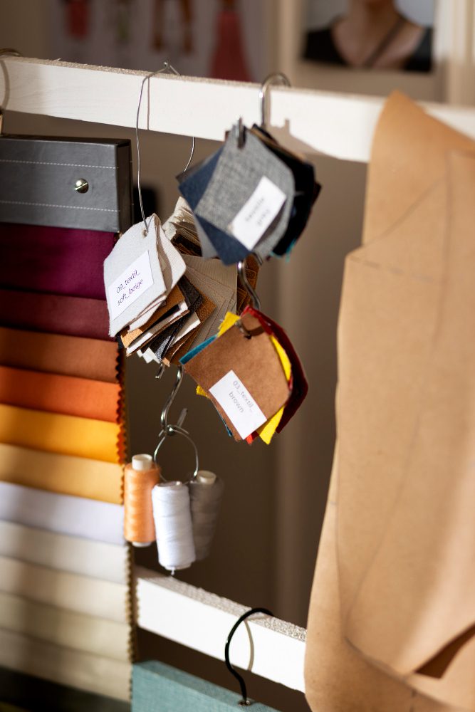 Fashion design workspace at js uniform showing fabric swatches and color palettes for custom t-shirt orders.